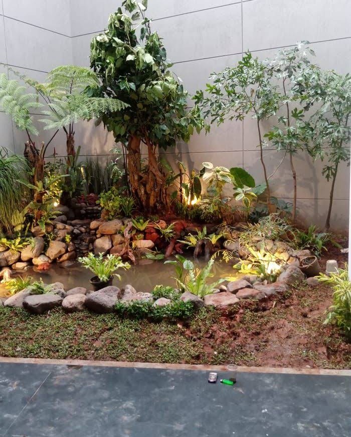 Sudut taman dengan kolam kecil, batu, dan tanaman